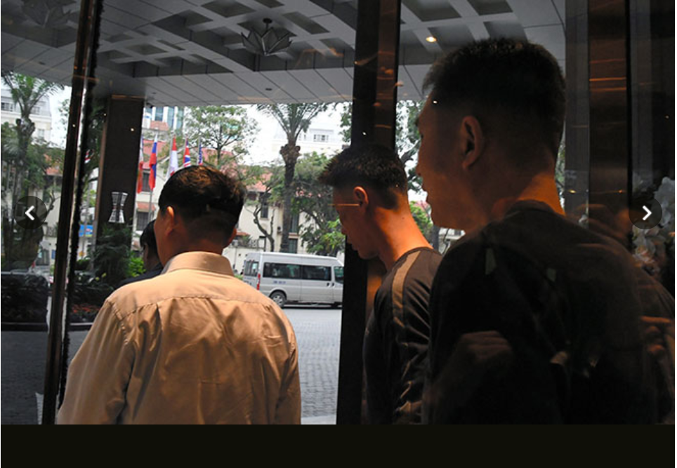 Vệ sĩ Triều Tiên ra khỏi một khách sạn ở Hà Nội và tránh mọi câu hỏi của phóng viên. Ảnh: Asahi. 