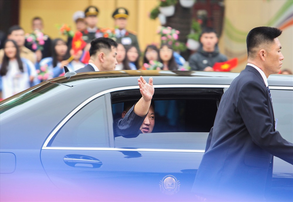 Ông Kim Jong-un vẫy tay khi trên xe di chuyển về Hà Nội. 
