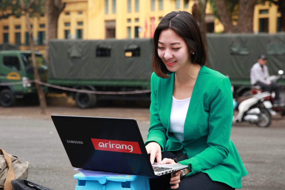 Dù gặp sự cố về vấn đề kỹ thuật trong quá trình tác nghiệp xong nữ phóng viên Hee-jun Christine Park – đài Arirang vẫn luôn nở nụ cười trên môi. Ảnh: Hải Nguyễn. 