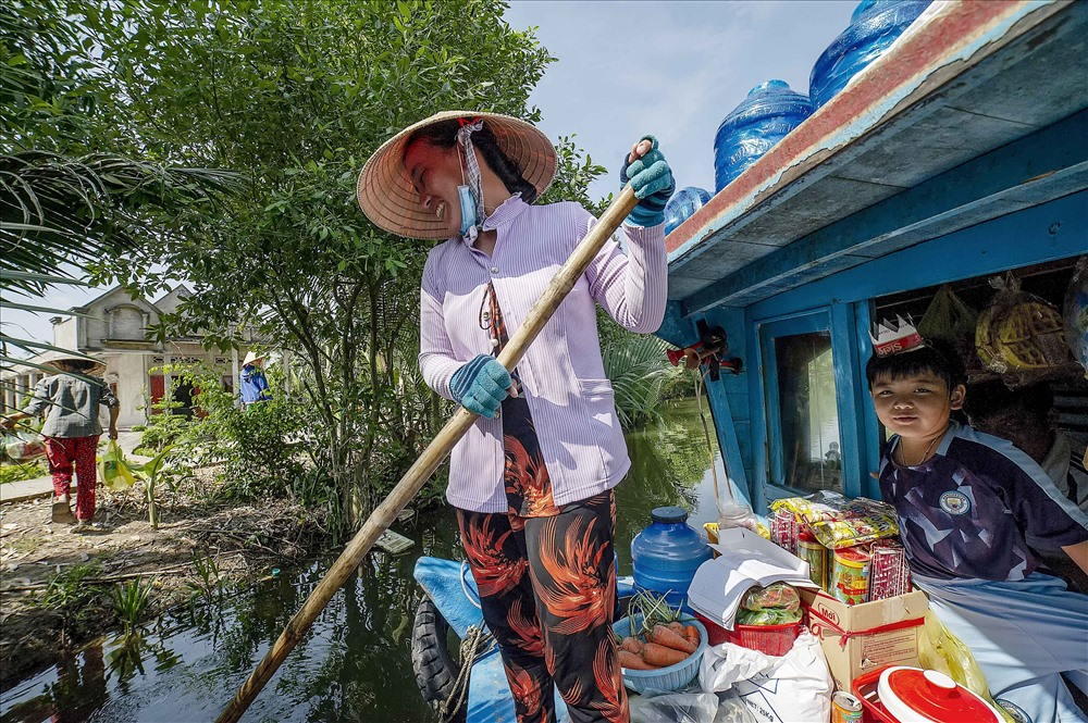 Người bán ghe hàng cập bến chuẩn bị bán hàng hóa cho người thôn quê