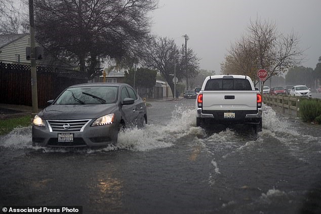Những chiếc xe được lái qua những con đường ngập nước trong khu vực Panorama City của Thung lũng San Fernando ở Los Angeles.
