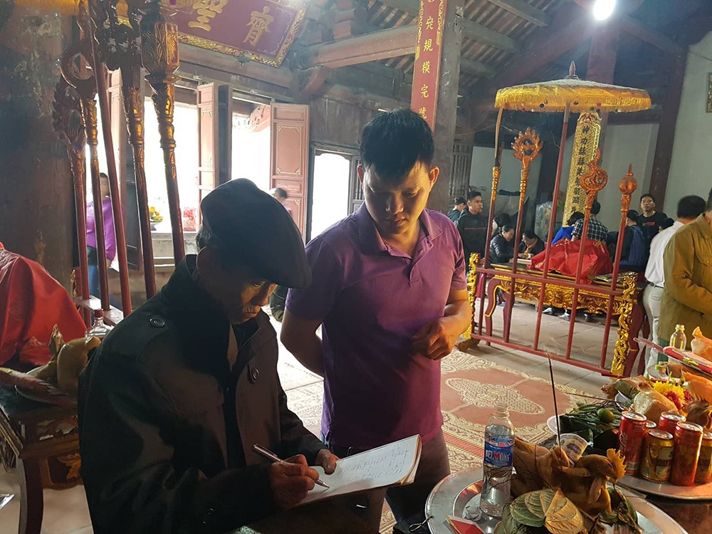 Ông Nguyễn Văn Nghi là chủ Bái giúp mọi người dâng lễ tại đền.