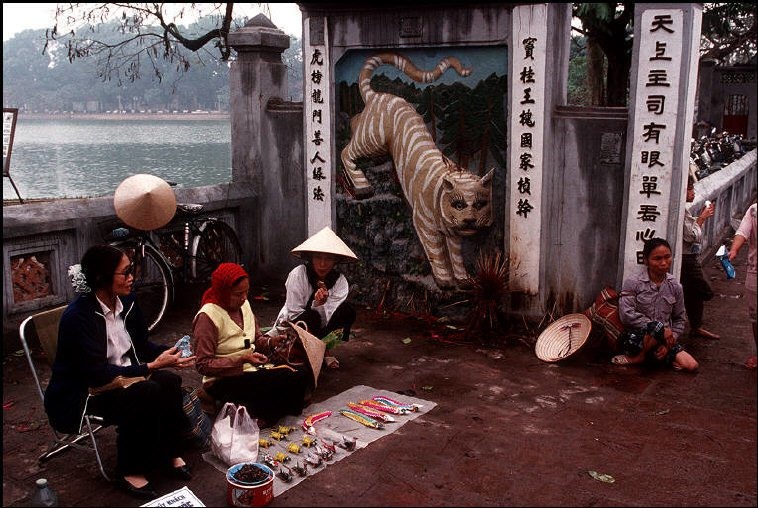 Những người khắc dấu và bán đồ chơi thủ công trước cửa đền Ngọc Sơn.  