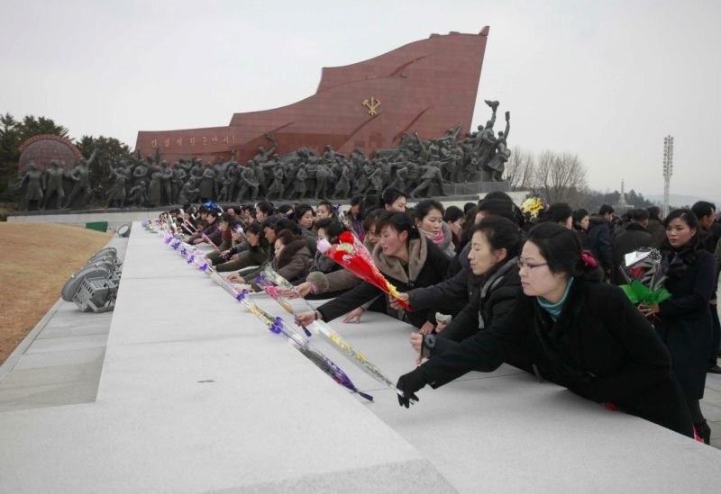 Tại thủ đô của Triều Tiên du khách đặt những bó hoa tại các bức tượng của cố lãnh đạo Kim Nhật Thành và cố lãnh đạo Kim Jong-il trong ngày đầu năm mới. Ảnh: AP. 