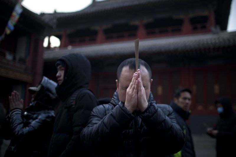 Những người dân Bắc Kinh đi lễ tại một ngôi đền trong sáng ngày 5.2. Ảnh: AP. 