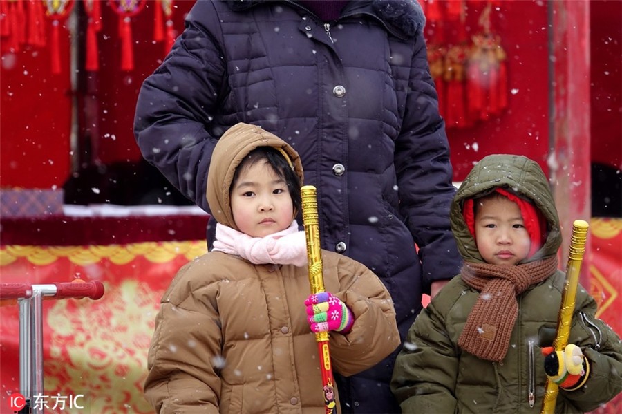 Hai đứa trẻ ngắm tuyết rơi tại một hội chợ được tổ chức ở ngoại ô phía tây Bắc Kinh.