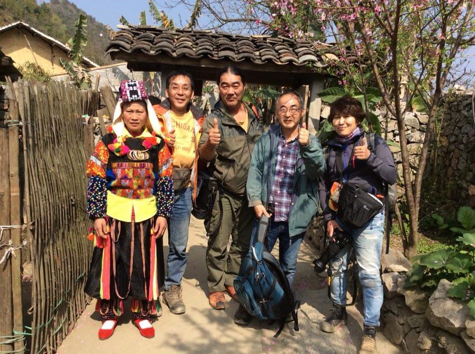 Ông Yasushi Ogura (thứ 2, từ phải sang) chụp ảnh cùng du khách Nhật tại Đồng Văn. Ảnh do nhân vật cung cấp