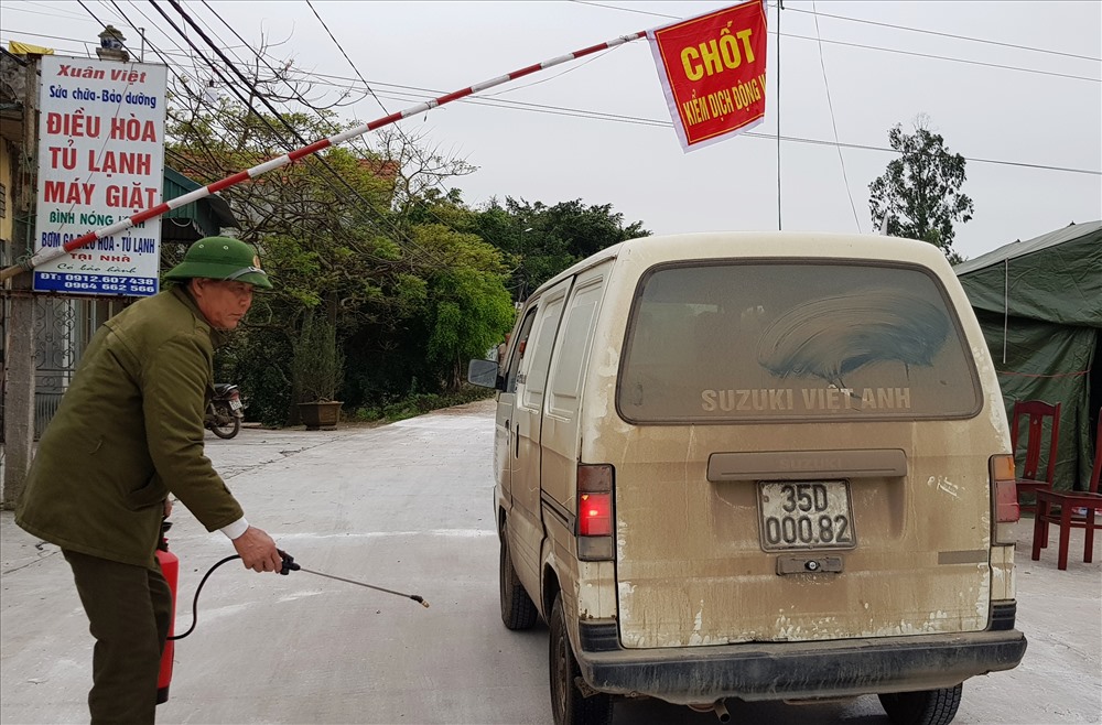 Tất cả các phương tiện ra vào vùng dịch đều được phun hóa chất khử trùng. Ảnh: NT