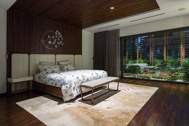 Phòng ngủ được thiết kế ấm cúng với tông màu nâu ấm và đẹp mắt hơn nhờ bể cá phía bên cạnh cửa sổ.