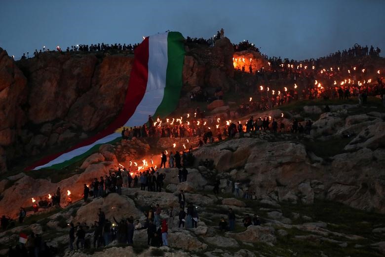 Lực lượng người Kurd dùng những ngọn đuốc thắp sáng một ngọn núi mừng lễ hội Newroz ở thị trấn Akra, Iraq.