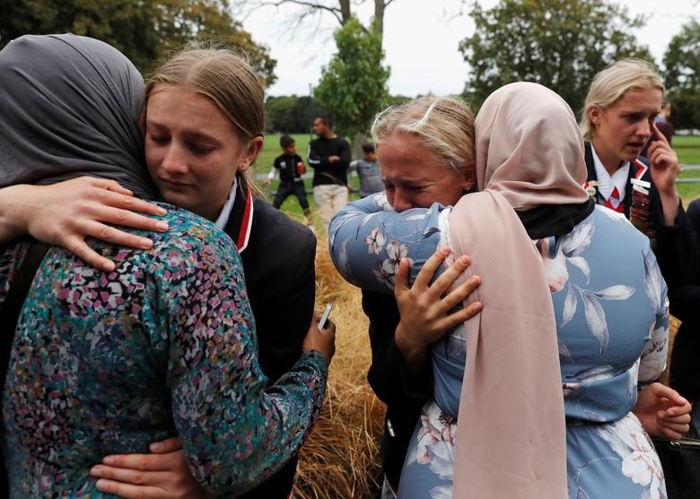 Vụ xả súng hàng loạt làm 50 người thiệt mạng ở thành phố Christchurch, New Zealand. Trong hình là những học sinh trung học của một trường Thiên chúa giáo ôm những người Hồi giáo đang chờ đợi tin tức về người thân của họ tại một trung tâm cộng đồng.