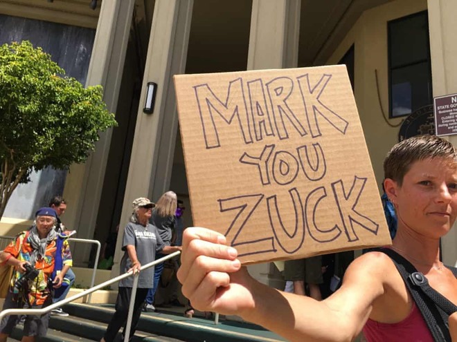 Nhiều người phản đối cầm theo biểu ngữ chế nhạo CEO Facebook. Ảnh: Jon Letman.