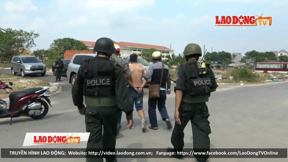 Cảnh sát áp tải một đối tượng trong đường dây ma túy do Wu Hao Shan cầm đầu ra xe đặc chủng vào ngày 20.3 cừa qua. Ảnh: T.S