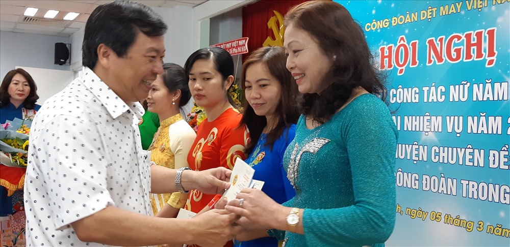 Ông Lê Trung Hải, Phó Tổng giám dốc Vinatex, tặng hoa, kỷ niệm chương cho các nữ CNVCLĐ ngành dệt may tại đầu cầu TPHCM. Ảnh Đức Long