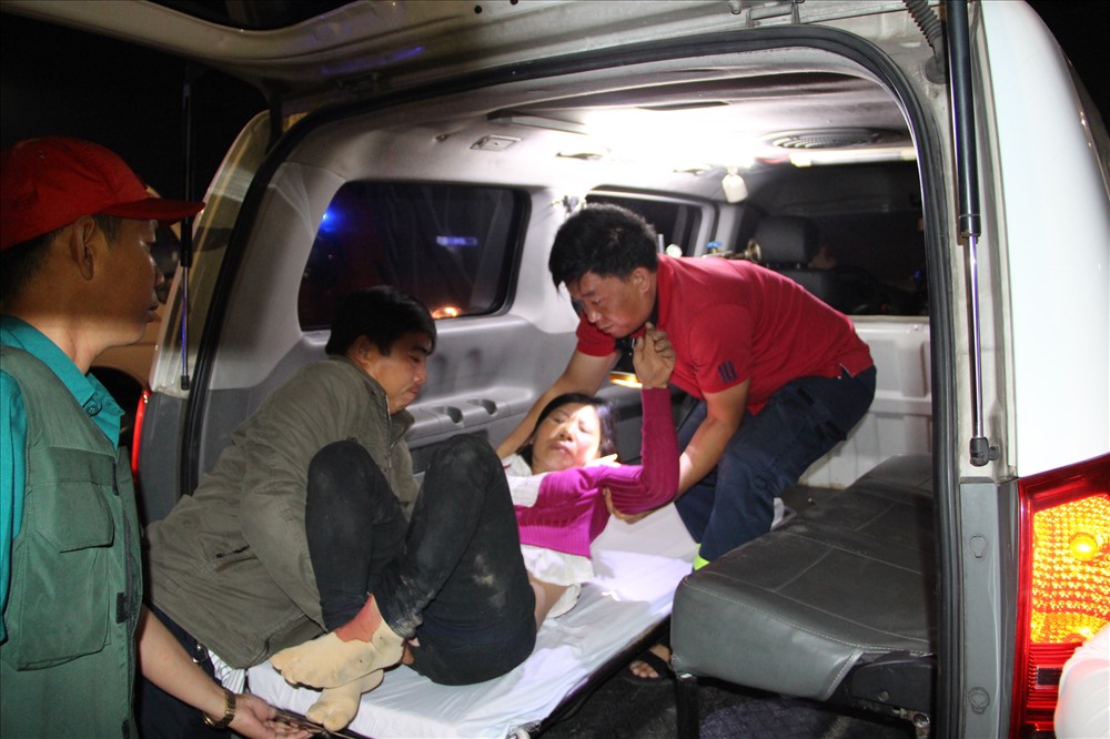 Nữ hành khách bị mắc kẹt được giải cứu đưa lên xe đi bệnh viện.