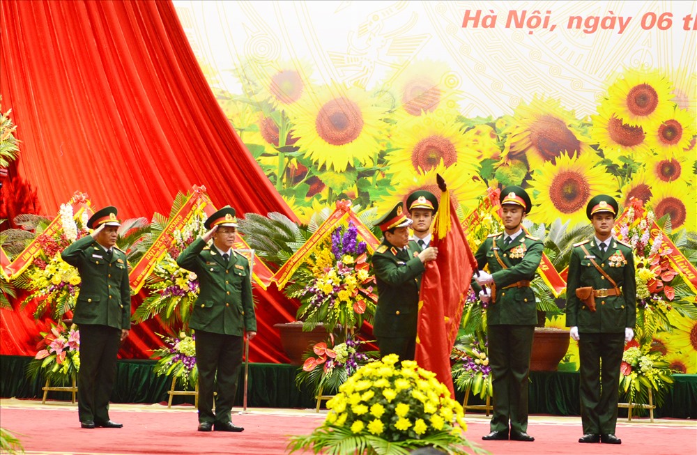 Đại tướng Lương Cường gắn Huân chương Bảo vệ Tổ quốc lên lá cờ Quyết Thắng của Ban CĐ Quốc phòng. Ảnh: Quang Thắng