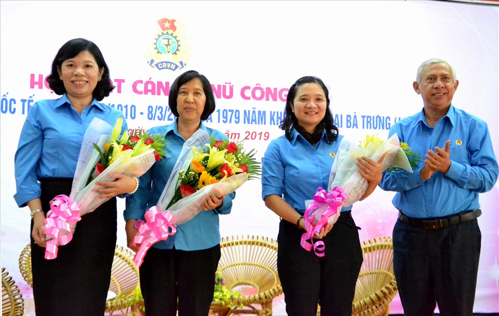 Chủ tịch LĐLĐ An Giang Nguyễn Thiện Phú tặng hoa cho 3 đại biểu tham gia giao lưu. Ảnh: Lục Tùng
