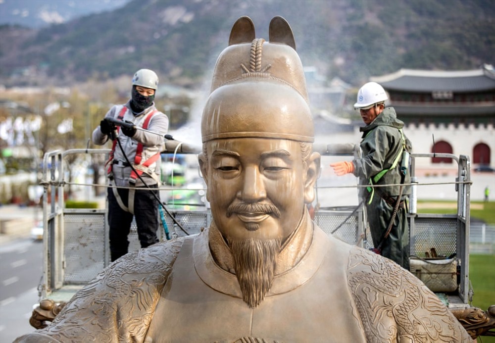 Công nhân là sạch bức tượng Đại đế Sejong ở quảng trường Gwanghwamun.  Sejong là vị vua thứ tư của triều đại Joseon, trị vì từ  năm 1418 – 1450  ( Ảnh: Yonha / EPA)