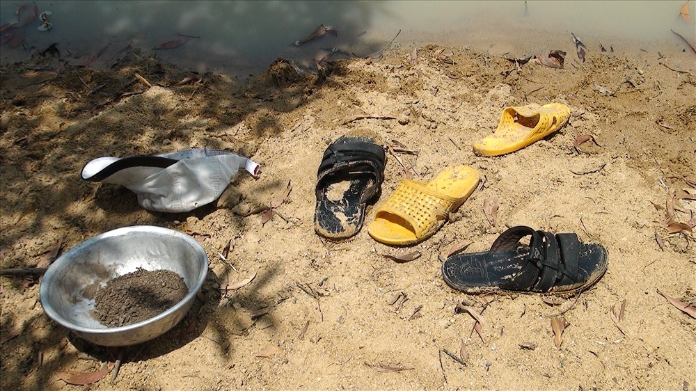 Các đôi dép của 3 em học sinh tiểu học để lại trên bờ. Ảnh: P.V