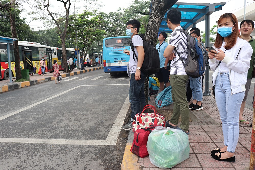 Thay vì đi xe ôm, nhiều người chờ đi xe bus do phải mang vác nhiều đồ đạc lỉnh kỉnh.