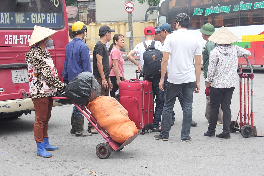 Nhiều người vì mang theo quá nhiều đồ, không thể tự di chuyển phải thuê xe ba gác chở ra ngoài cổng.