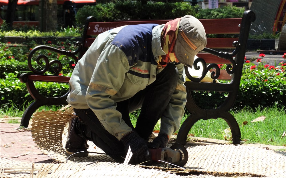Trang bị tránh nắng từ đầu tới chân của một người thợ chế tác đang thi công cho sự kiện Festival Hoa lan tại công viên Tao Đàn, quận 1