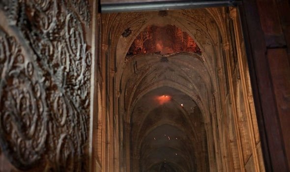 Ngọn lửa và khói âm ỉ bên trong nhà thờ Đức Bà ở Paris, Pháp, ngày 16.4. Ảnh: EAP