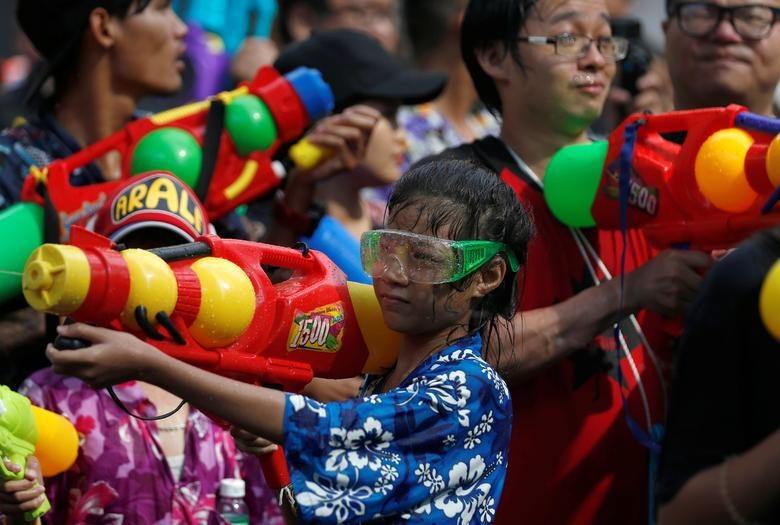 Những khẩu súng nước đủ hình dạng rất được ưa chuộng trong lễ hội Songkran ở Bangkok. Cậu bé Thái Lan dùng súng nước bắn vào mọi người khi cùng đám đông hòa vào lễ hội Songkran.