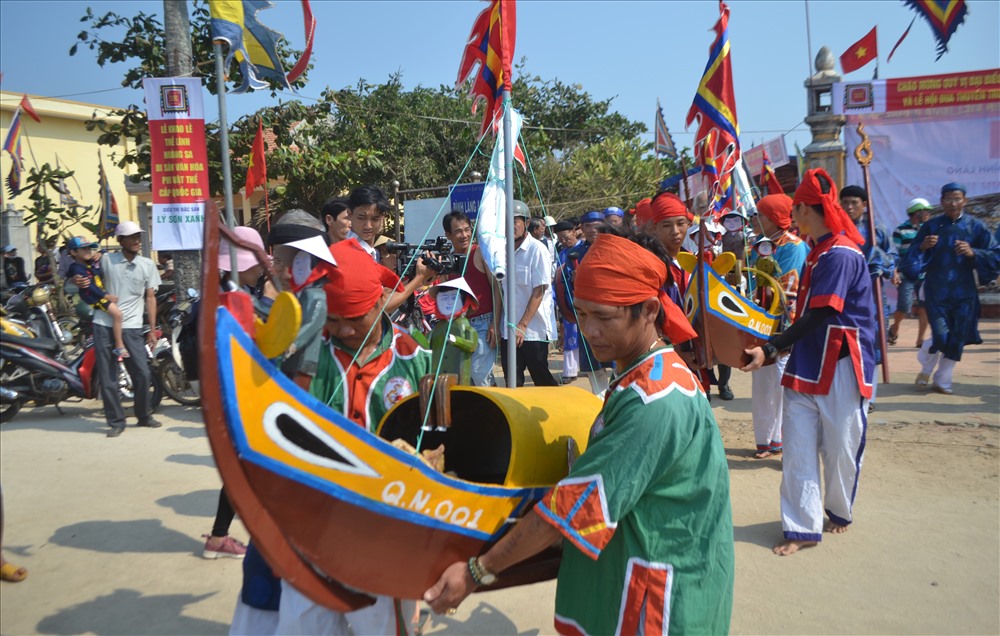 Các trai tráng làng An Vĩnh làm lễ rước thuyền ra biển.