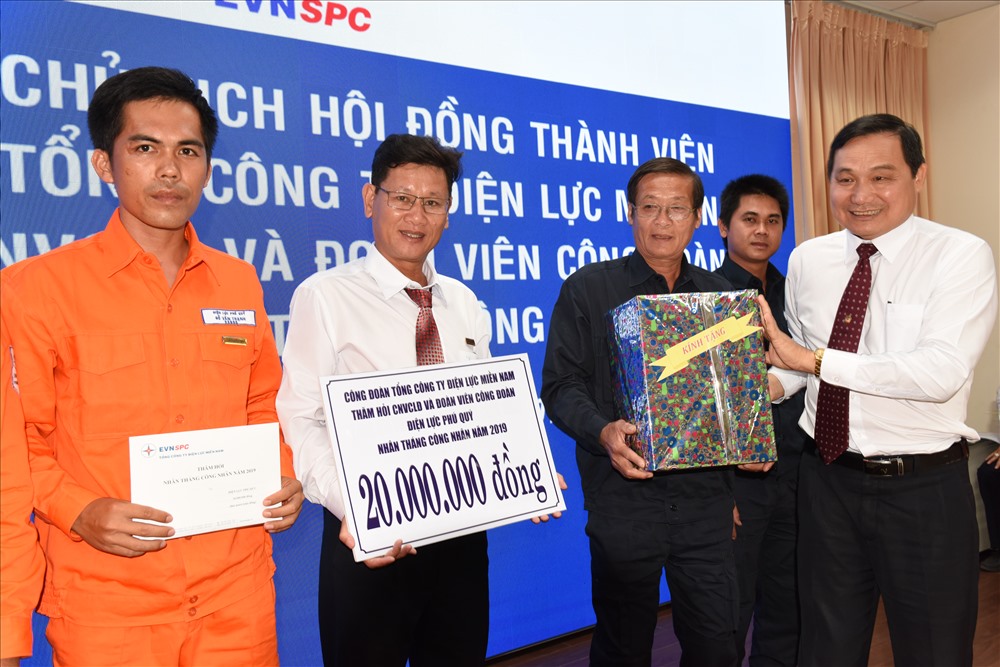 Ông Nguyễn Văn Hợp - Chủ tịch Hội đồng thành viên TCty Điện lực miền Nam (phải ảnh) tặng quà cho anh chị em đang làm việc tại Điện lực Phú Quý