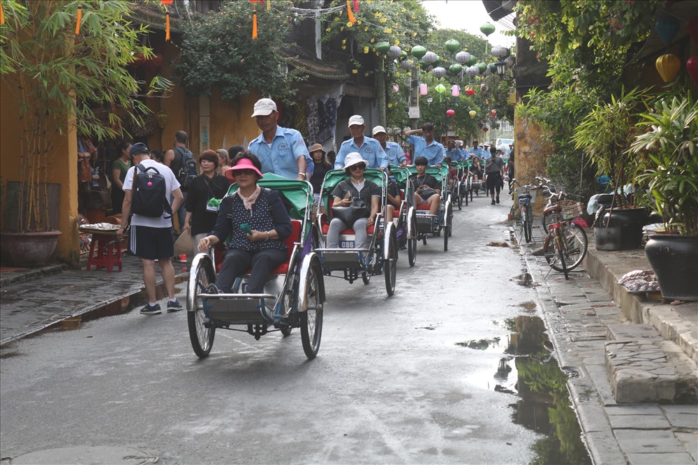 Một đoàn khách quốc tế tham quan phố cổ Hội An bằng xe xích lô. Ảnh: Đ.V