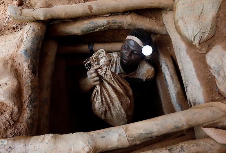 Một người khai thác thủ công trèo ra khỏi mỏ vàng tại khu khai thác không có giấy phép của Nsuaem Top ở Ghana.