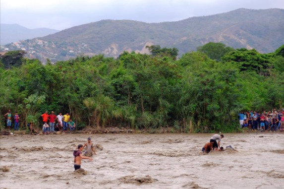 Do các cây cầu nối với Colombia bị chặn, người dân Venezuela phải lội qua sông Tachira để tới thành phố Cucuta ở bên kia biên giới.