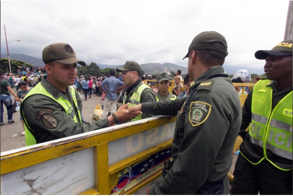 Một cảnh sát Colombia bắt tay với một người bảo vệ của Venezuela.