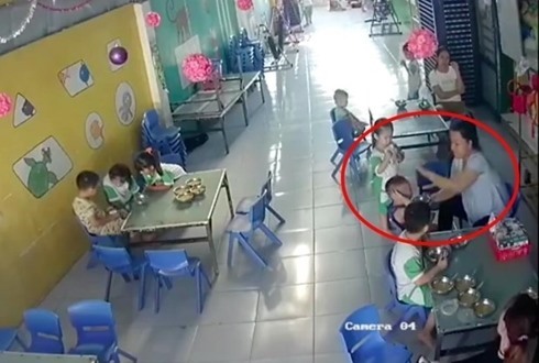 Hình ảnh cô giáo vừa cho trẻ ăn, vừa đánh liên tiếp vào đầu trẻ trước sự chứng kiến của 2 bảo mẫu khác.