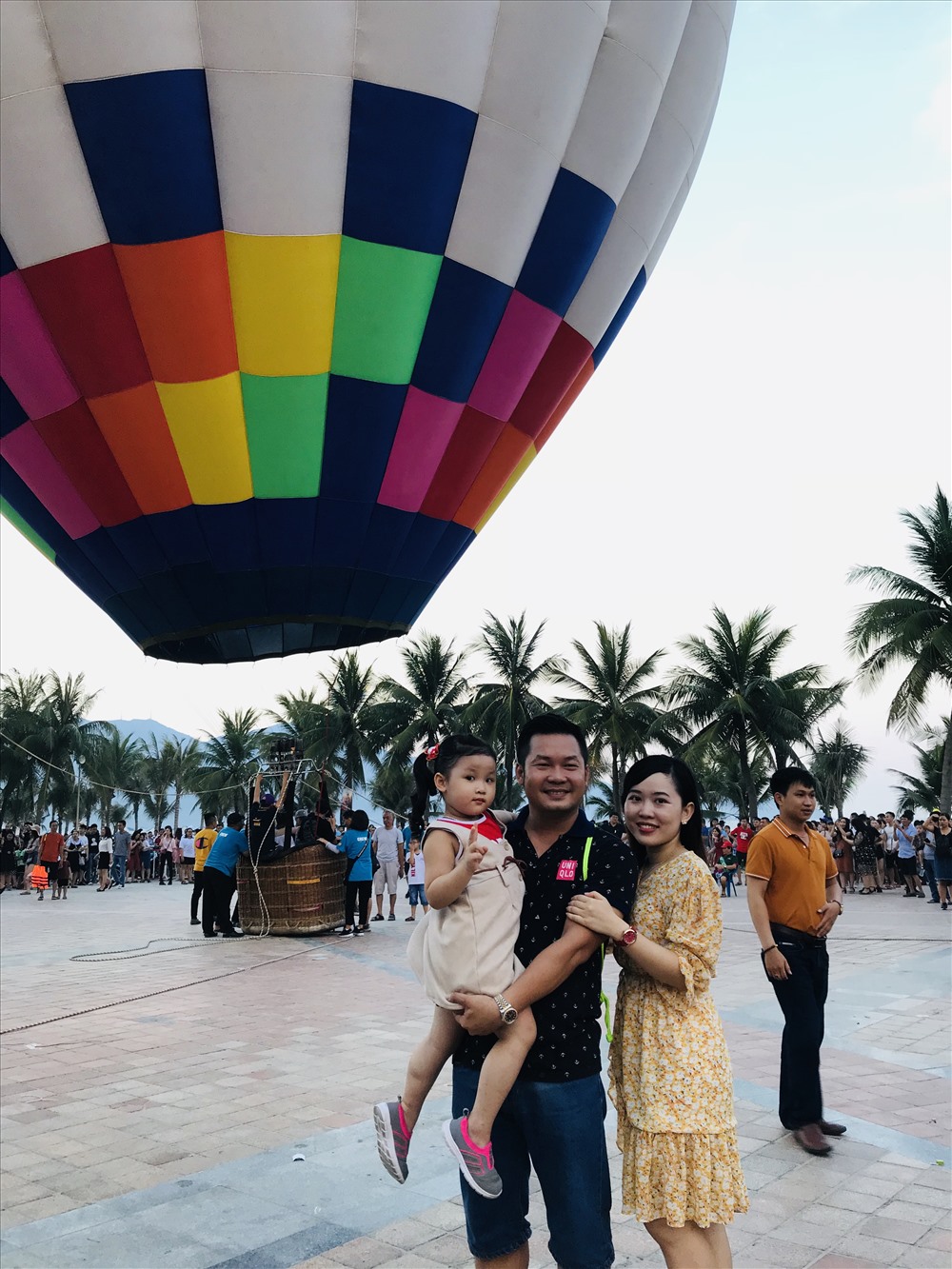 Một gia đình khách du lịch tranh chụp ảnh lưu niệm với khinh khí cầu.