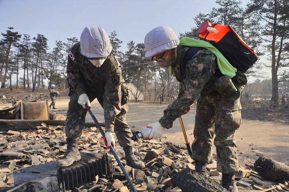 Các binh sĩ Hàn Quốc cố gắng dập tắt đám cháy vẫn còn trong những mảnh vụn âm ỉ sau khi khu vực này bị hỏa hoạn ở Goseong. Ảnh: AFP