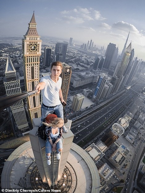  Dimitriy Chernysh và bạn gái Polina, trái, trên đỉnh của một tòa nhà chọc trời ở Dubai. Dimitriy, 22 tuổi, đến từ Moscow, biết rằng Polina luôn muốn nhìn thấy những tòa nhà chọc trời của Dubai, vì vậy anh đã đưa cô thẳng lên đó. Họ đã chụp lại khoảng khắc cả hai cùng trên lóc của một tòa nhà. 