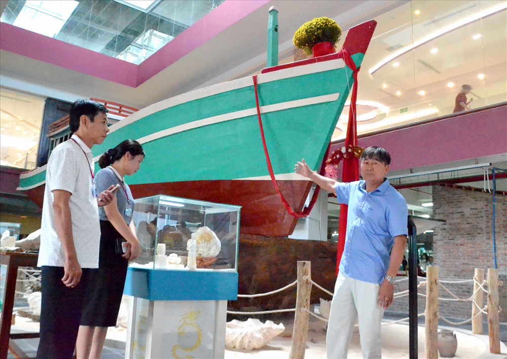 Ông Hồ Phi Thủy tự hào giới thiệu với du khách về con thuyền gắn bó với mình như định mệnh. Ảnh: Lục Tùng