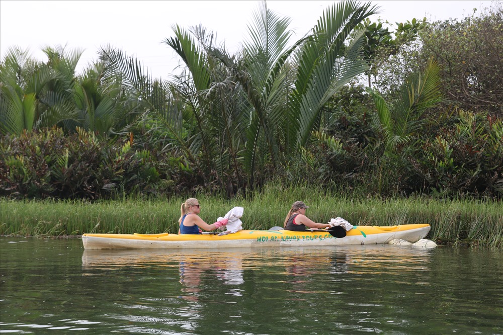Khách du lịch chèo thuyền Kayak đi vớt rác ở Hội An. Ảnh: Đ.V