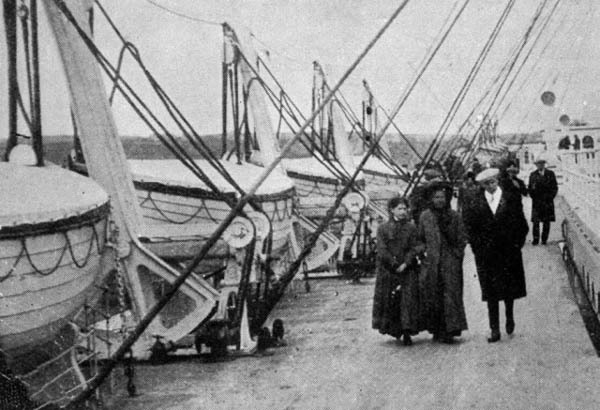 Hành khách đi bộ trên tàu Titanic bên cạnh xuồng cứu sinh, thứ mà vài ngày sau họ phải sử dụng chúng.