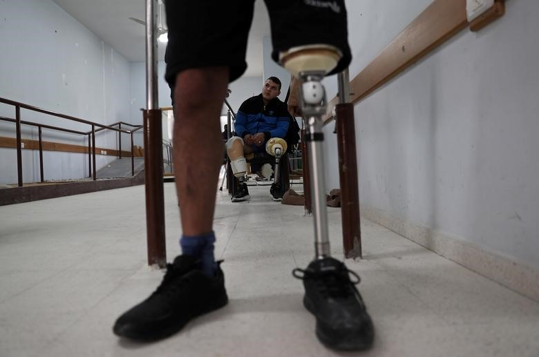 Anh Abdallah Qassem (17 tuổi), người Palestine đã bị mất cả hai chân sau khi anh bị lực lượng Israel bắn trong một cuộc biểu tình ở biên giới Israel-Gaza. Abdallah Qassem ngồi lặng trên chiếc xe lăn trong một trung tâm chân tay giả ở thành phố Gaza ngày 2 tháng 4 năm 2019. Qassem nói viên đạn bắn vào một chân và sau đó xuyên qua chân kia khi anh ta ngồi trên mặt đất với bạn bè trong một cuộc biểu tình vào ngày 14.5.2018, ngày Hoa Kỳ chuyển đại sứ quán từ Tel Aviv đến Jerusalem, làm tăng thêm sự tức giận của người Palestine. “chỉ là một viên đạn, một viên đạn làm đảo lộn cuộc sống của tôi “, Abdallah Qassem đau đớn nói