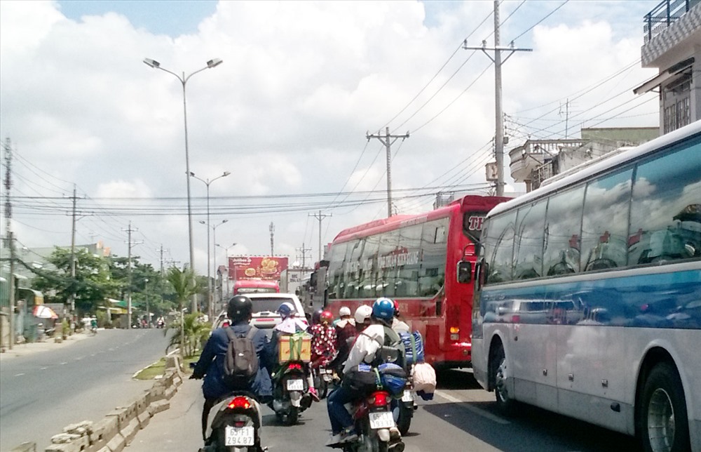 Trên Quốc lộ 91, hướng về phà Vàm Cống ùn ứ kéo dài hàng cây số, trong khi hướng ngược lại vắng vẻ.