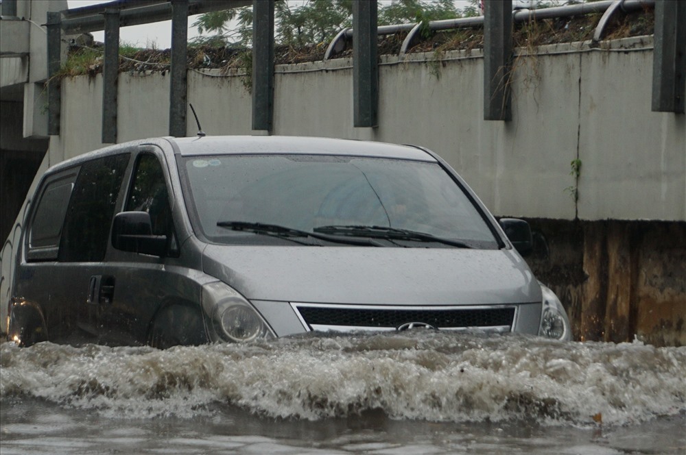 Ô tô gần như ngụp lặp trong nước đi chuyển qua đường Nguyễn Hữu Cảnh.
