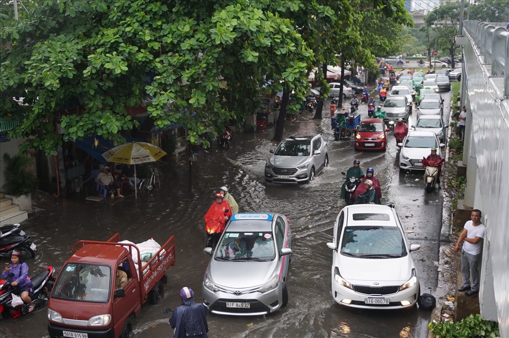 Một tài xế ôtô thấy phía trước nước ngập sâu, sợ xe chết máy nên không chịu di chuyển, gây nên cảnh kẹt xe kéo dài trên đường Nguyễn Hữu Cảnh.