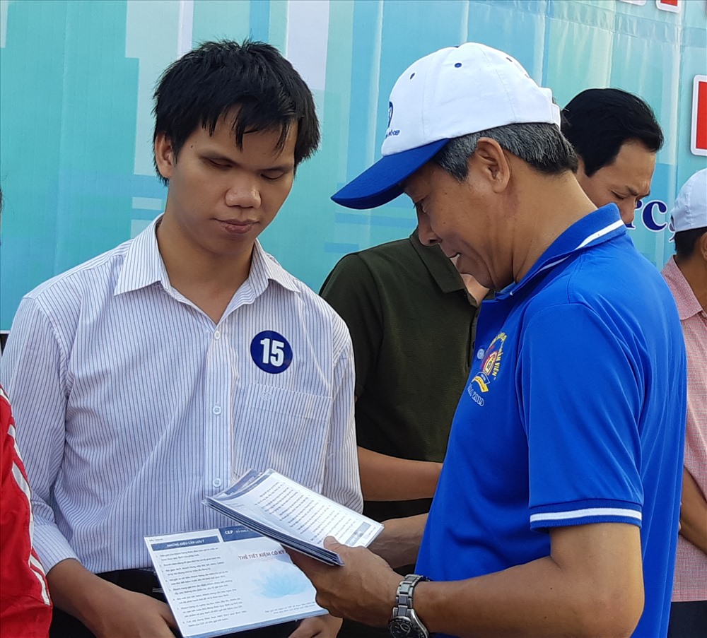 Ông Đặng Nguyễn Thanh Minh (phải), Chủ tịch UBND Quận Thủ Đức, trao sổ tiết kiệm cho CNLĐ có hoàn cảnh khó khăn. Ảnh Nam Dương