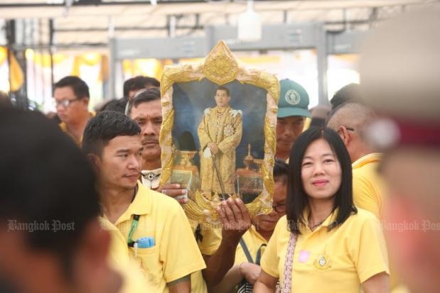 Người dân Thái Lan trong trang phục màu vàng giơ cao ảnh nhà vua tại đại lộ Ratchadamoen. Ảnh: Bangkok Post. 