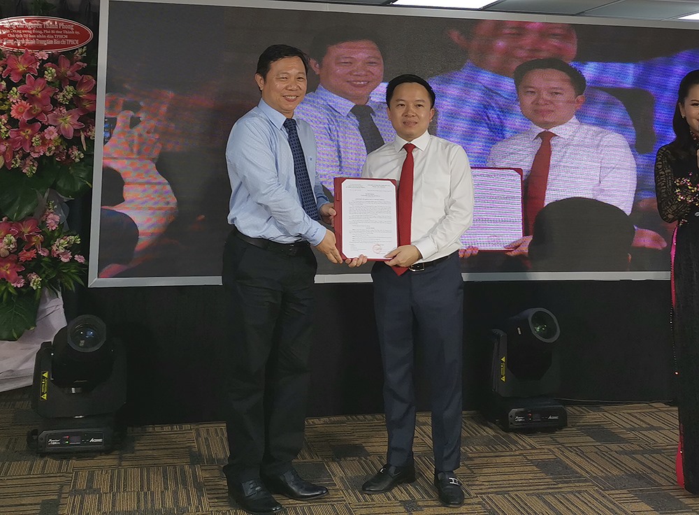 Ông Từ Lương (phải) - Phó giám đốc Sở Thông tin và Truyền thông TP.HCM nhận quyết định làm giám đốc đầu tiên của trung tâm báo chí đầu tiên tại TP.HCM.