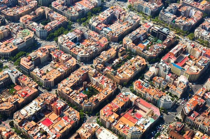 Nằm ở trung tâm thành phố Barcelona của Tây Ban Nha, quận Eixample được coi là một hình mẫu kinh điển cho cách thức quy hoạch đô thị kiểu bàn cờ. Được xây dựng trong quá trình mở rộng thành phố khi Barcelona bắt đầu phát triển vào giữa thế kỷ 19, quận Eixample có diện tích 7,5 km2, đặc trưng bởi những con phố thẳng, dài, đều tăm tắp giao cắt nhau. Nhìn từ trên cao, toàn khu vực trông như một mạng lưới ô bàn cờ. Trong mỗi ô bàn cờ, các khu nhà có quy hoạch kiến trúc giống nhau với hình khối bát giác, gọn gàng như những miếng xếp hình lego. Quận Eixample có khoảng hơn 200 khối nhà như vậy.