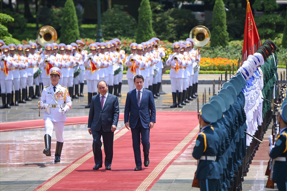 Sau đó, Thủ tướng Nguyễn Xuân Phúc mời Thủ tướng Giuseppe Conte duyệt đội danh dự và giới thiệu quan chức hai bên có mặt tại lễ đón. 